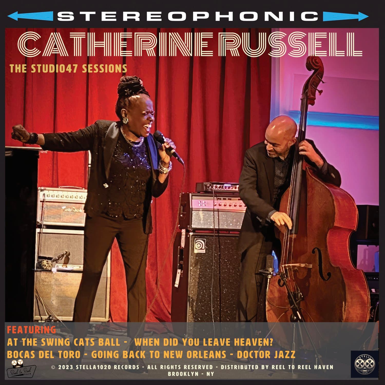 Catherine Russell performing with bassist at Studio47 Sessions, arms outstretched in an energetic pose